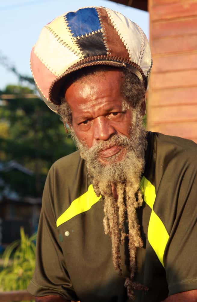 This is a rastafarian with dreadlocks wearing a rastacap.