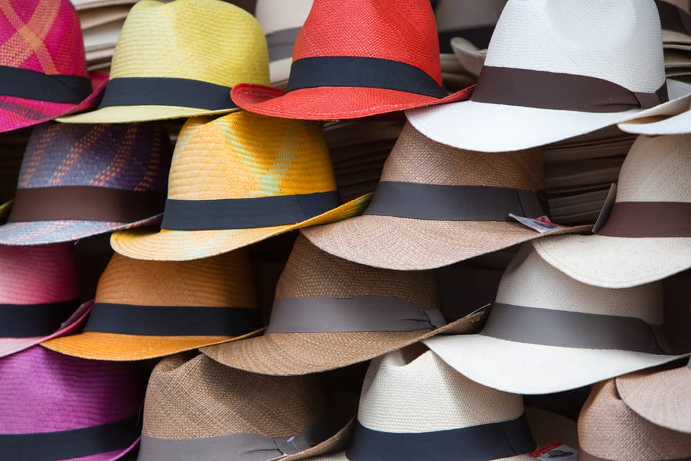 Stacks of panama hats on display in various colors.