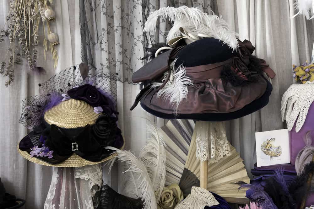 This is the window shop display of a Victorian shop featuring bonnets.