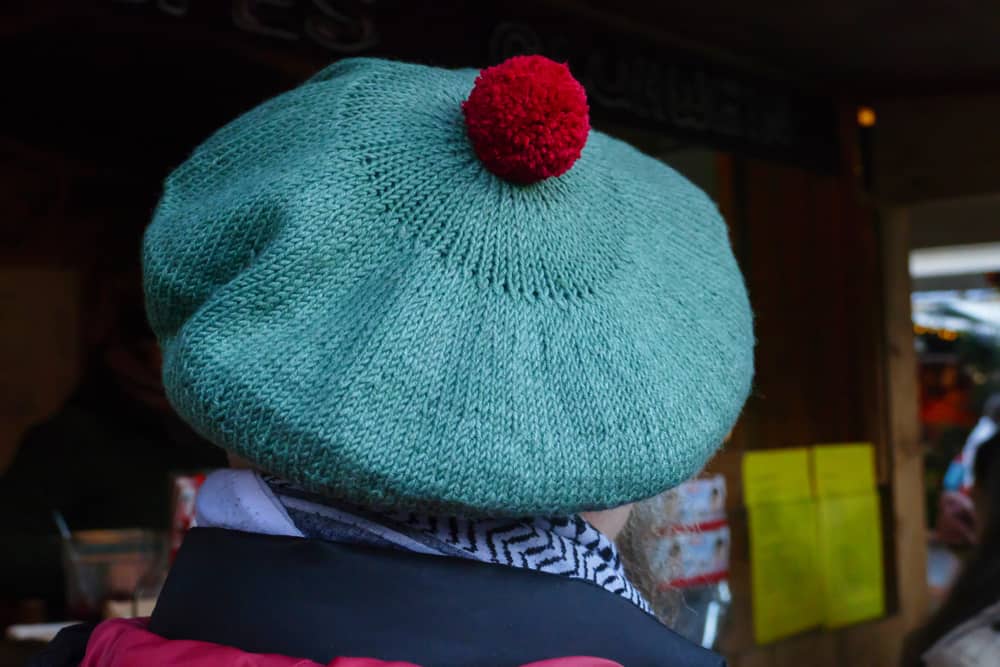 This is a close look at a man wearing a traditional knitted tam cap.