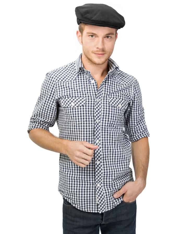 This is a man wearing a patterned button shirt with his ivy cap.