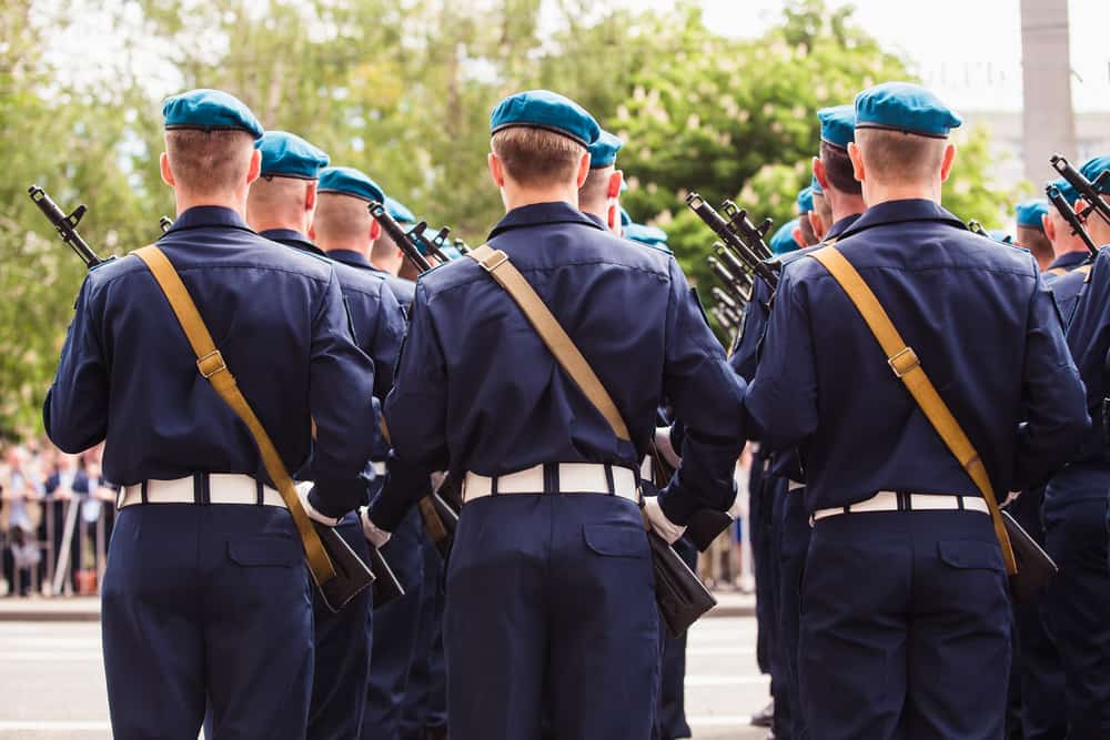These are military soldiers wearing a dark blue uniform topped with blue bonnets.