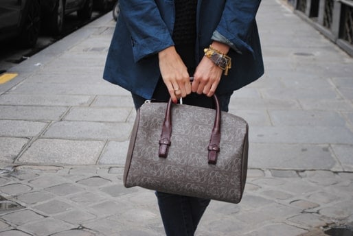 Woman holding a Boston taupe bag.