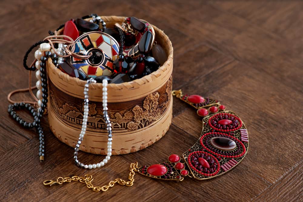 Various jewelries inside a round wooden box.