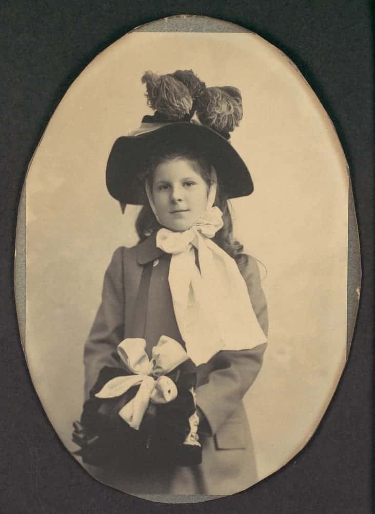 Girl in coat with hat and muff.