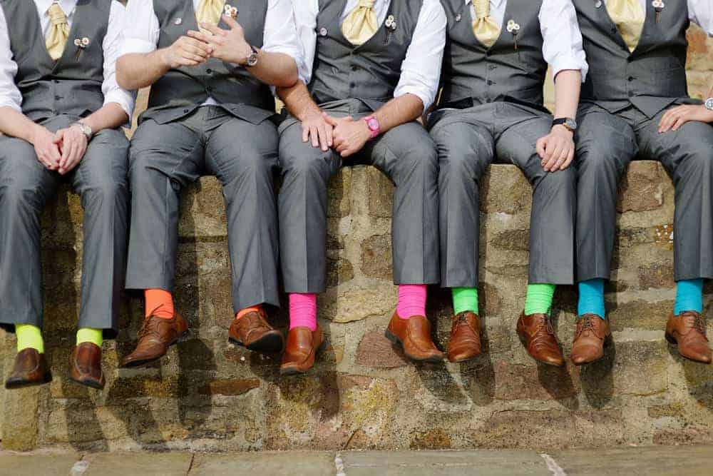 A group of men wearing colorful socks.