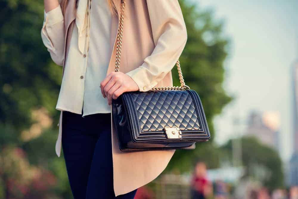 Woman carrying a black quilted bag.