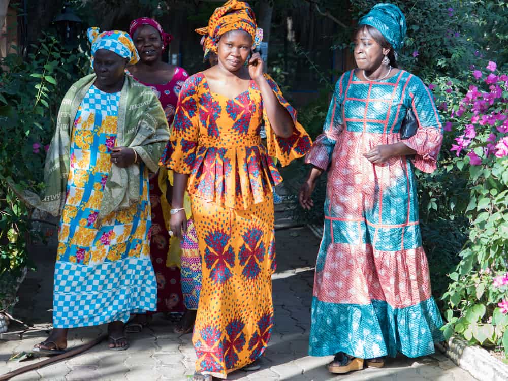 Senegalese women in their traditional costume walking at the park.
