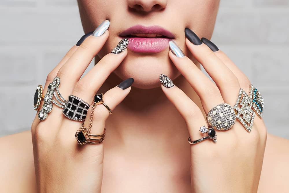 Woman hands filled with jewelry rings.