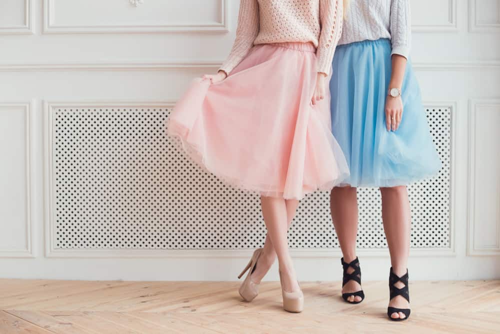 Two girls wearing pastel skirts ad high heels.