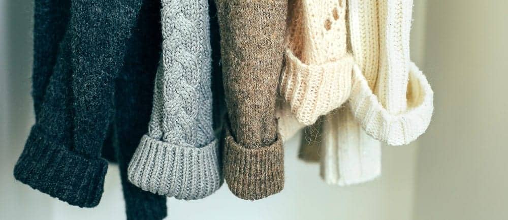 Closeup of multicolored knit sweaters.