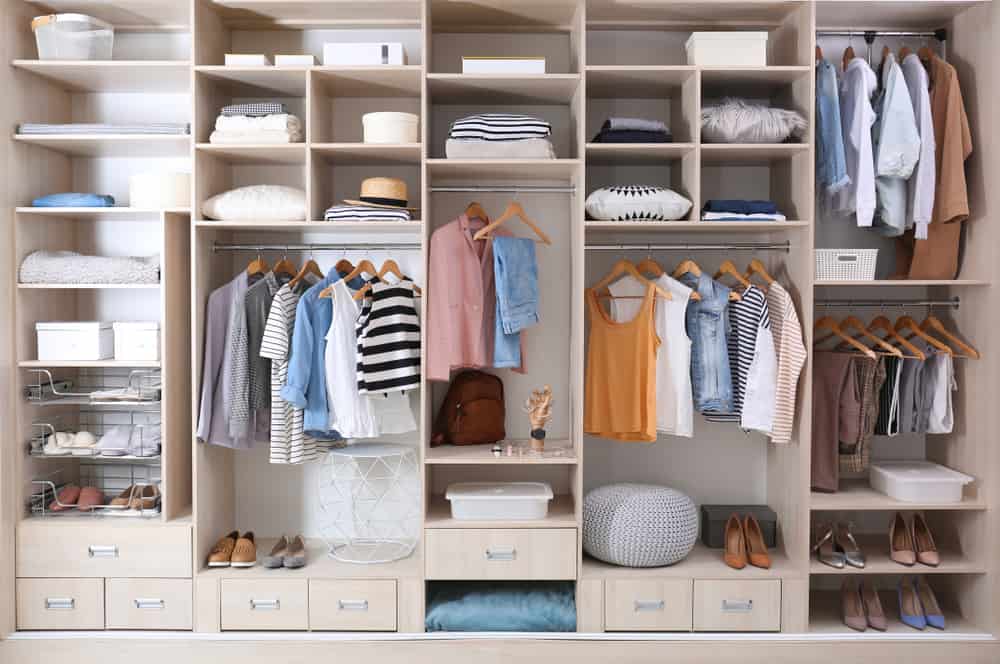 Built-in wardrobe filled with clothes and shoes.