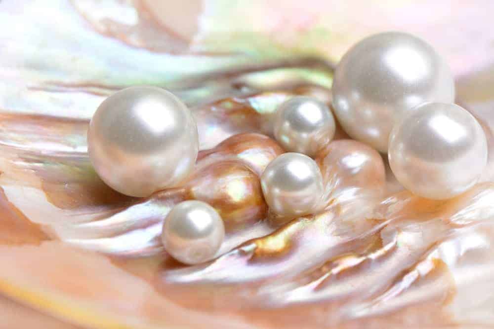 The different types of pearls on a satin sheet.
