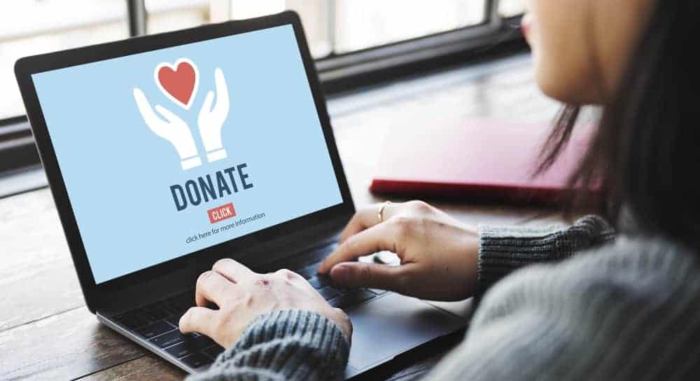 A woman browsing her laptop for ways to donate.