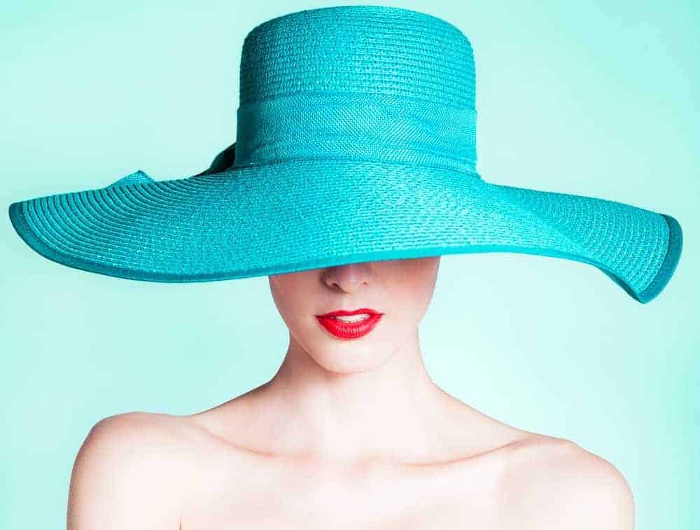 A woman wearing an aquamarine wide-brimmed hat.
