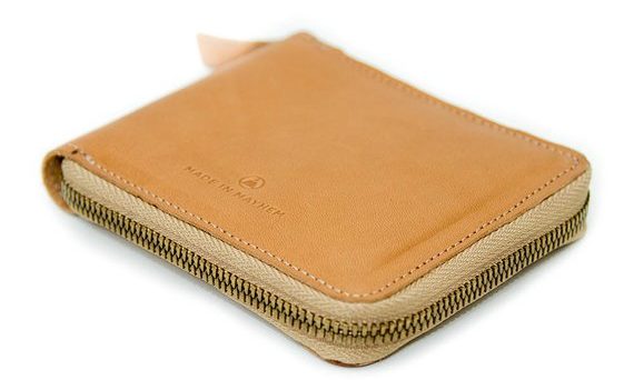 A small, zippered wallet in Tan.