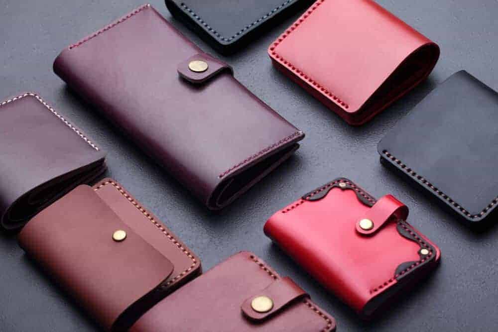 An assortment of leather wallets on a dark surface.