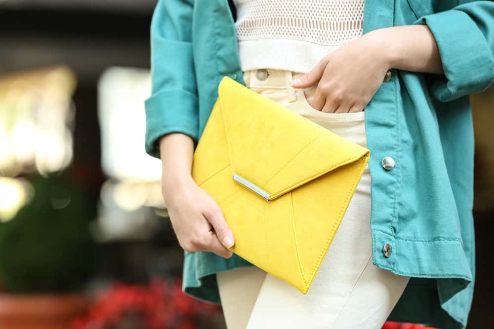 A close look at a woman carrying an envelope clutch.