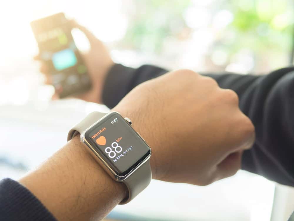 A close look at a man synching his smartwatch with his smart phone.