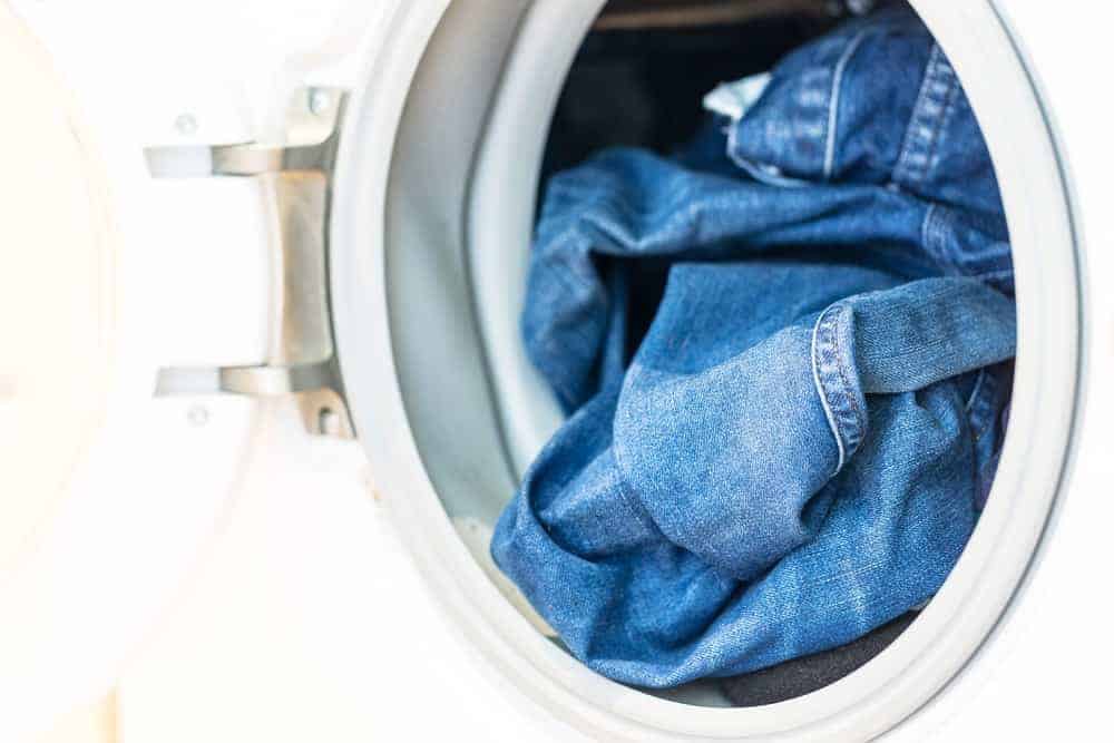 A close look at a pair of jeans inside the washing machine.