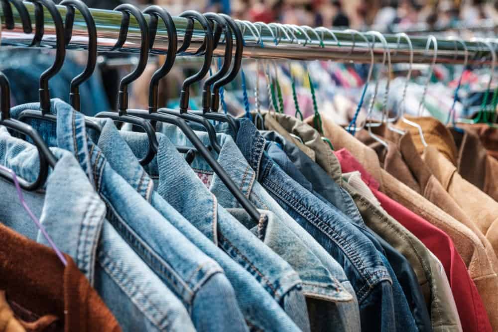 A close look at a rack of used clothes on display at a store.