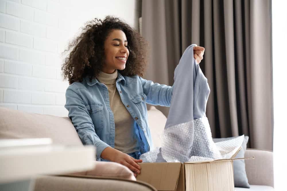 A woman inspecting the clothes she ordered online.