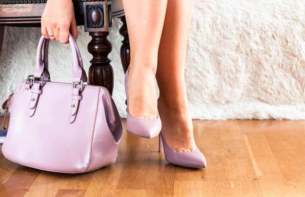 A close look at a woman wearing a pair of shoes that matches her bag.