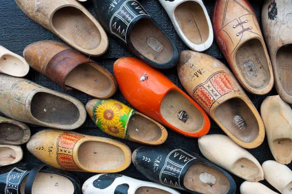 Various wooden clog shoes with different colorful designs.