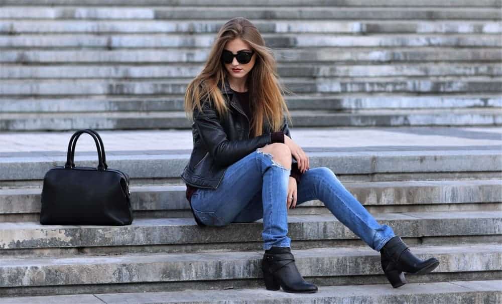 A woman wearing skinny jeans with her black leather jacket.