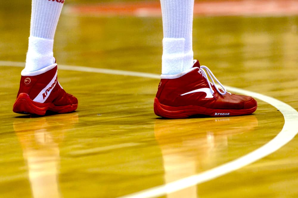 Basketball player wearing Nike red shoes during a game.