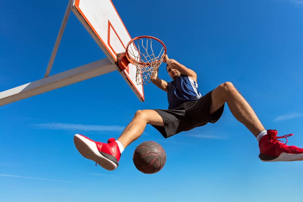 Basketball player making slam dunk.