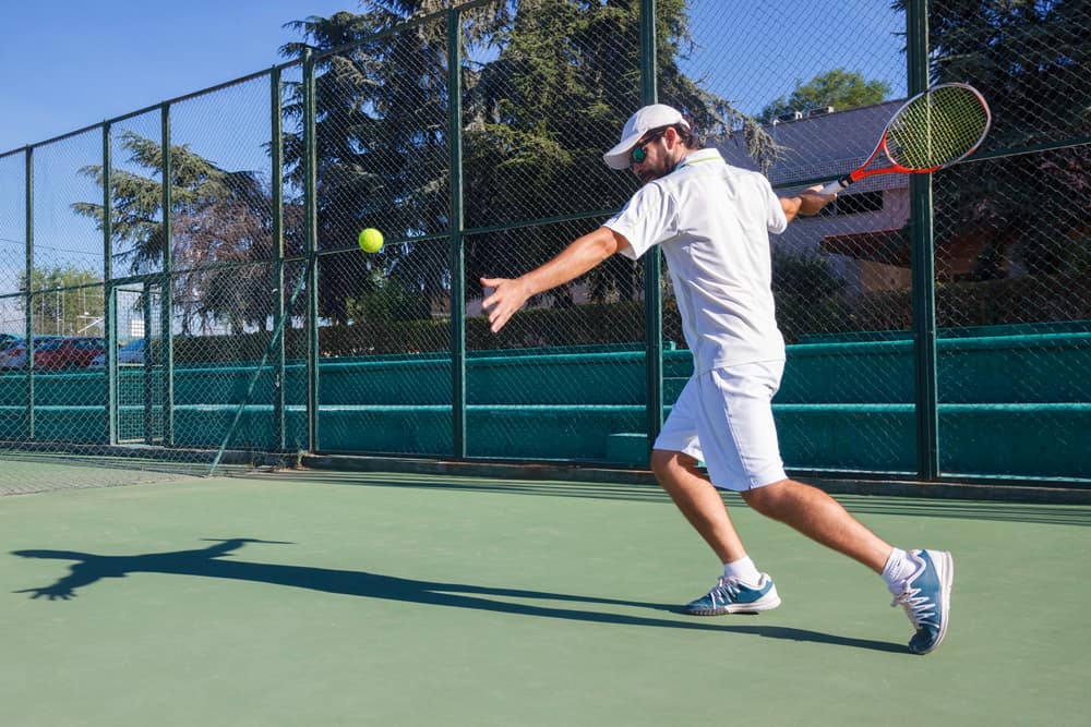 Man playing tennis on a court.