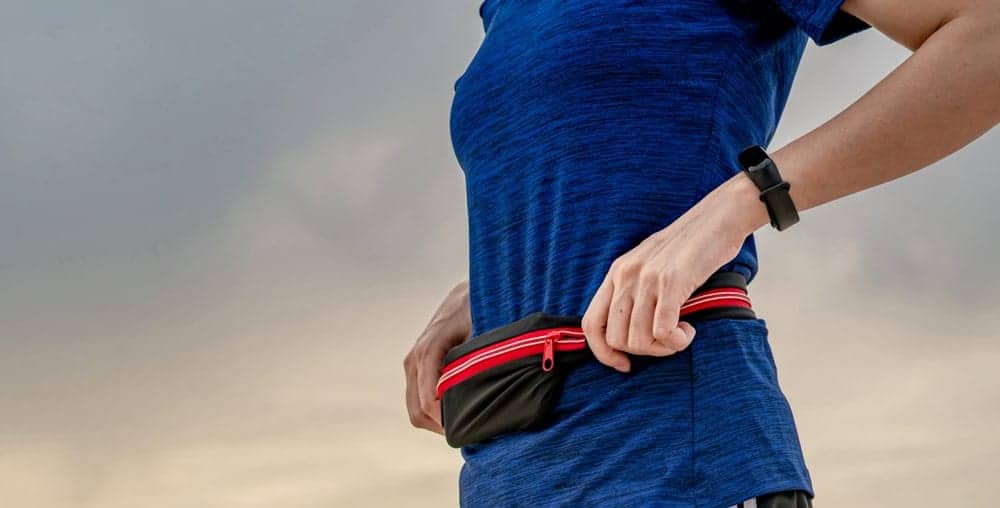 A close look at a woman wearing an athletic belt on her run.