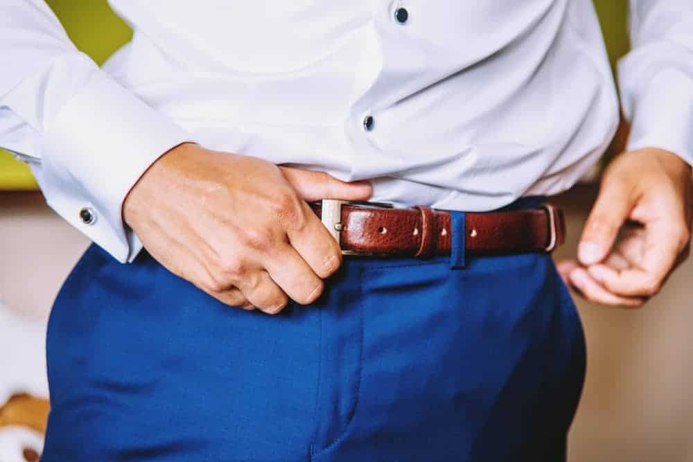 A man wearing a dress belt with his office clothes.