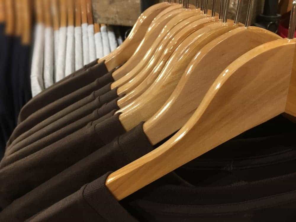 A close look at a row of wooden hangers at a store.