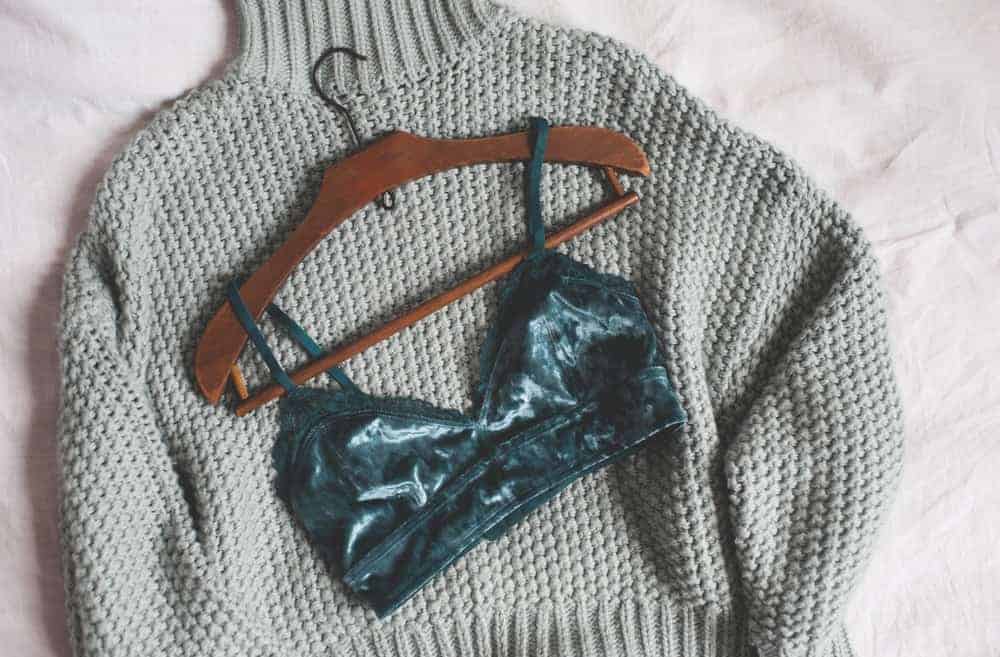 A gray sweater and a lingerie in a petite hanger.