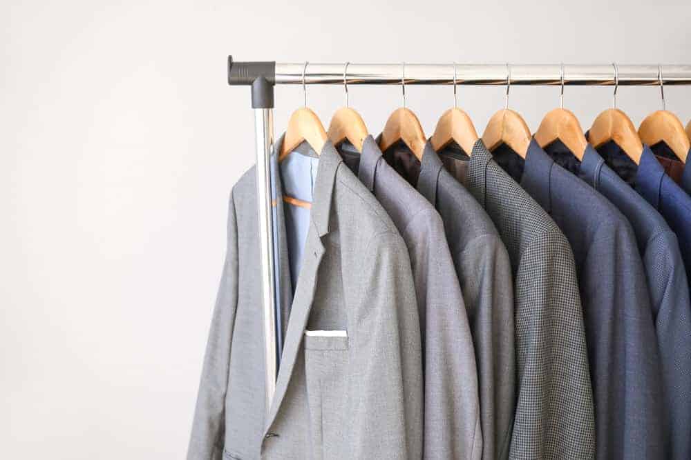 A rack of various coats supported by suit hangers.