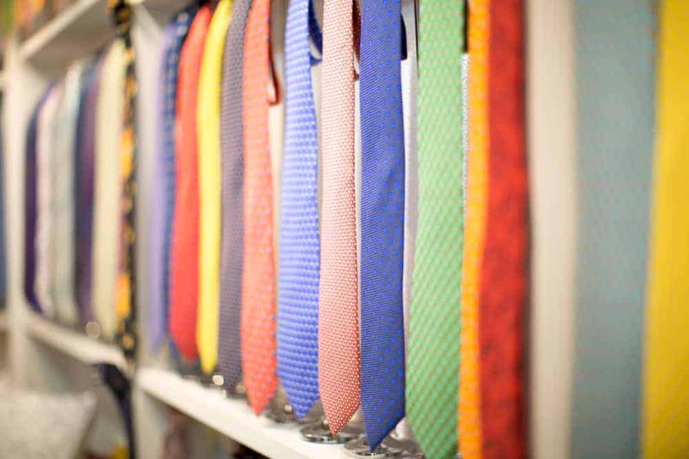 Colorful neckties on display supported by tie hangers.