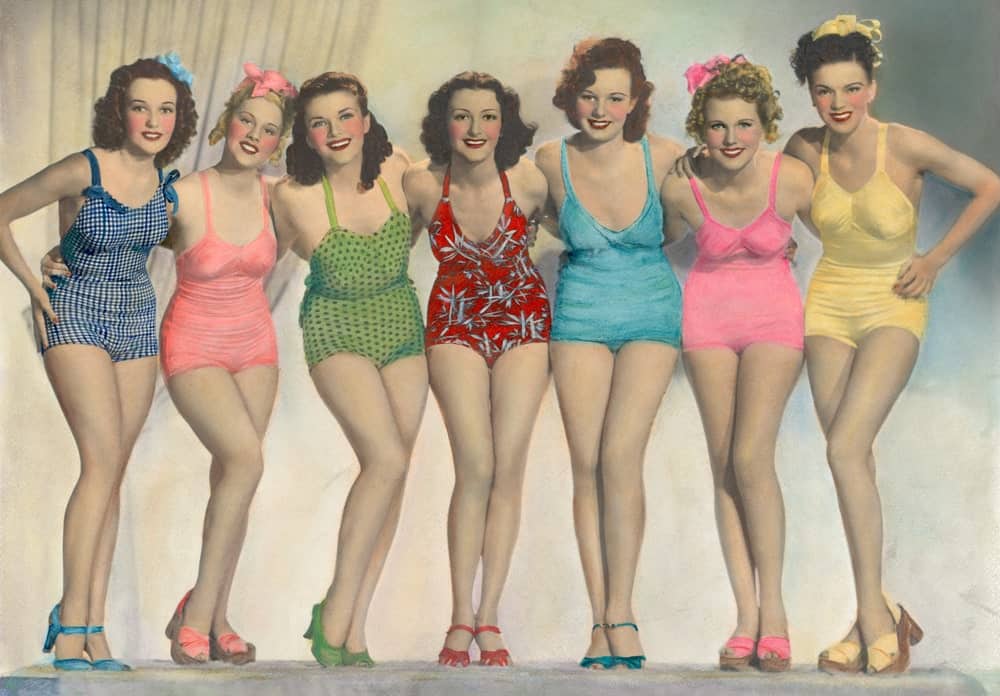 A group of women wearing classic one-piece bathing suits.