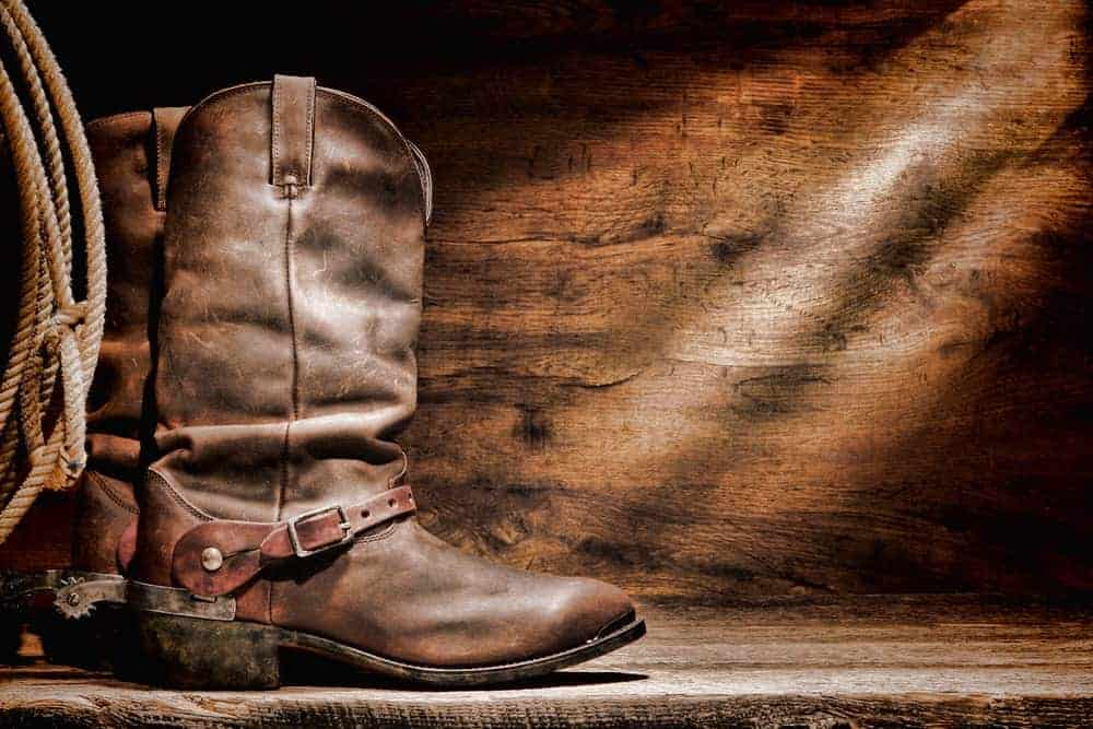A rustic pair of brown leather roper cowboy boots.