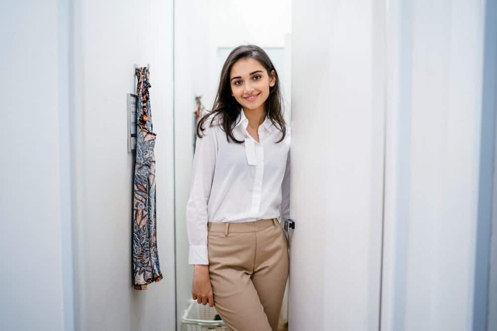 A woman wearing a white blouse with her khaki pants.