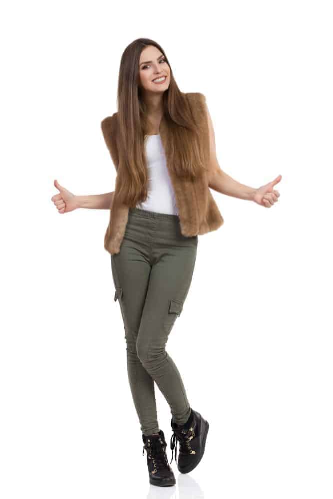 A woman wearing a pair of fitted khaki pants.