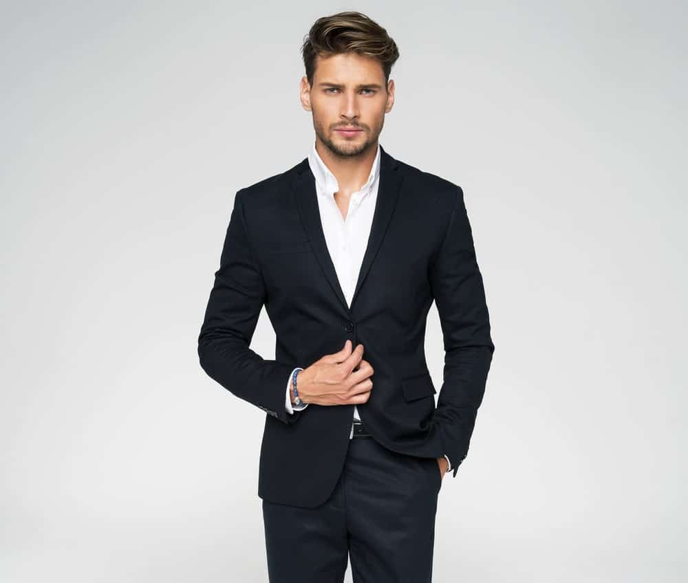 A man wearing a black slim fit suit.