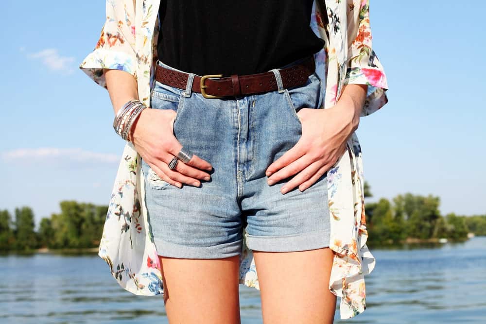 A close look at a woman wearing a pair of relaxed denim shorts.