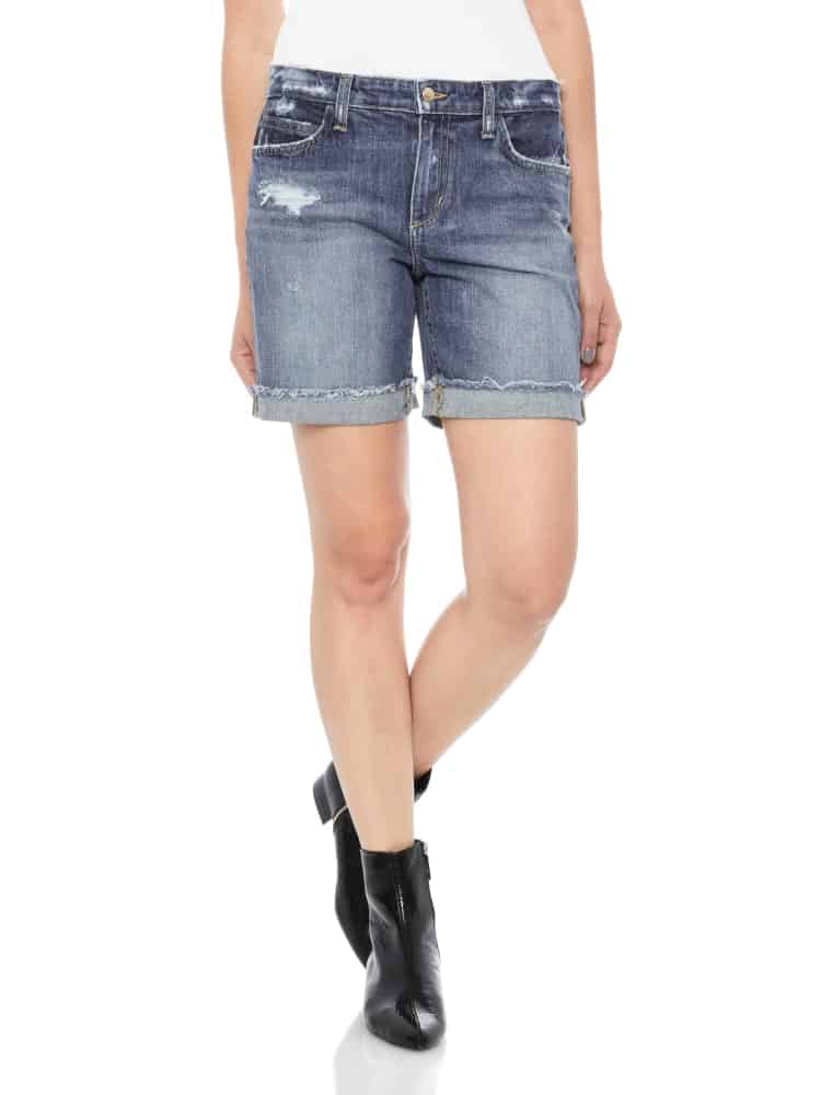 A woman wearing a pair of denim mid-length shorts.
