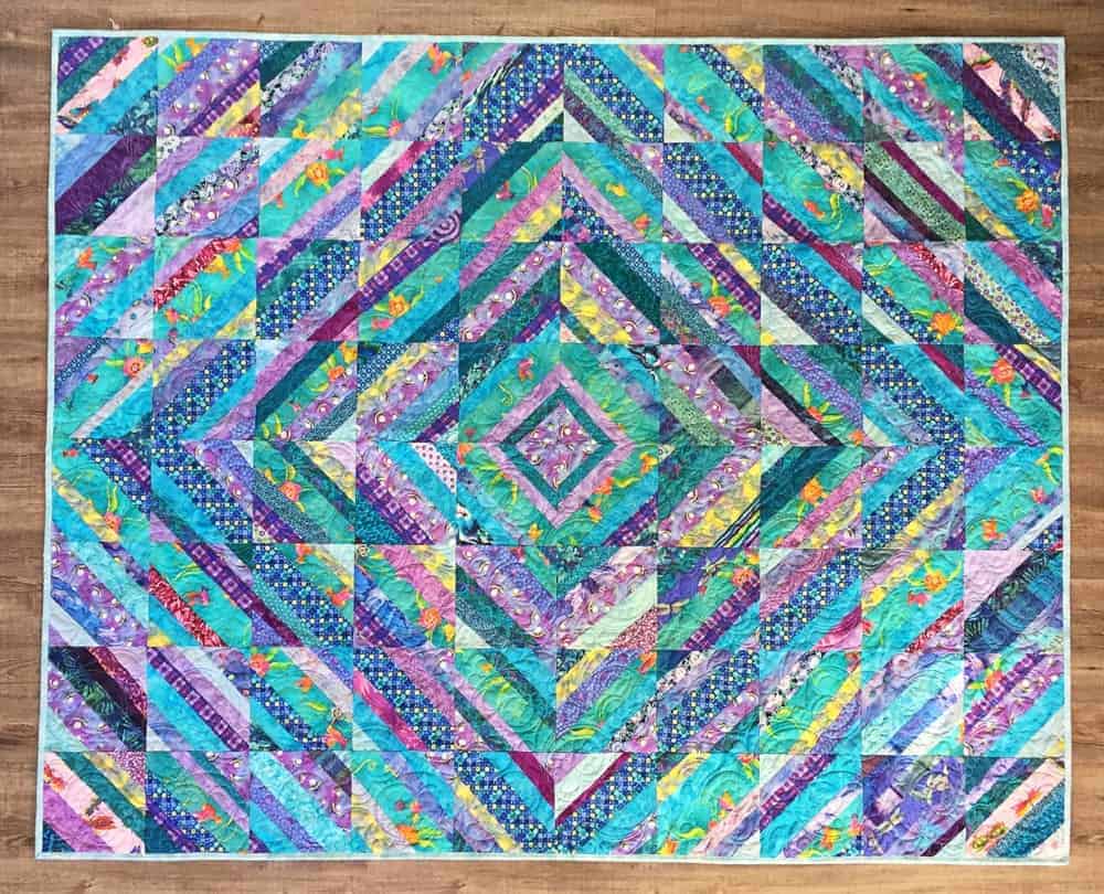 A colorful string quilt with patterns.