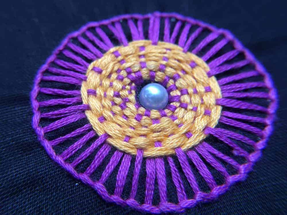A close look at a blanket stitch with a purple pattern.