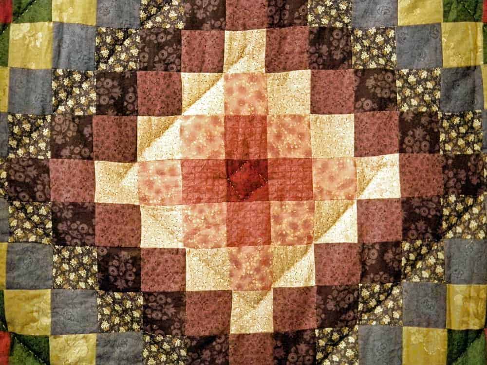 This is a close look at a colorful quilt with a diamond design.