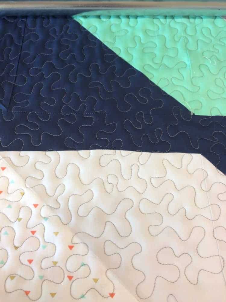A colorful quilt with stipple quilting design.