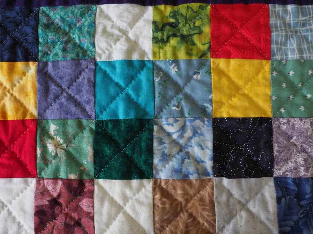 A colorful charm quilt with a checkered design.